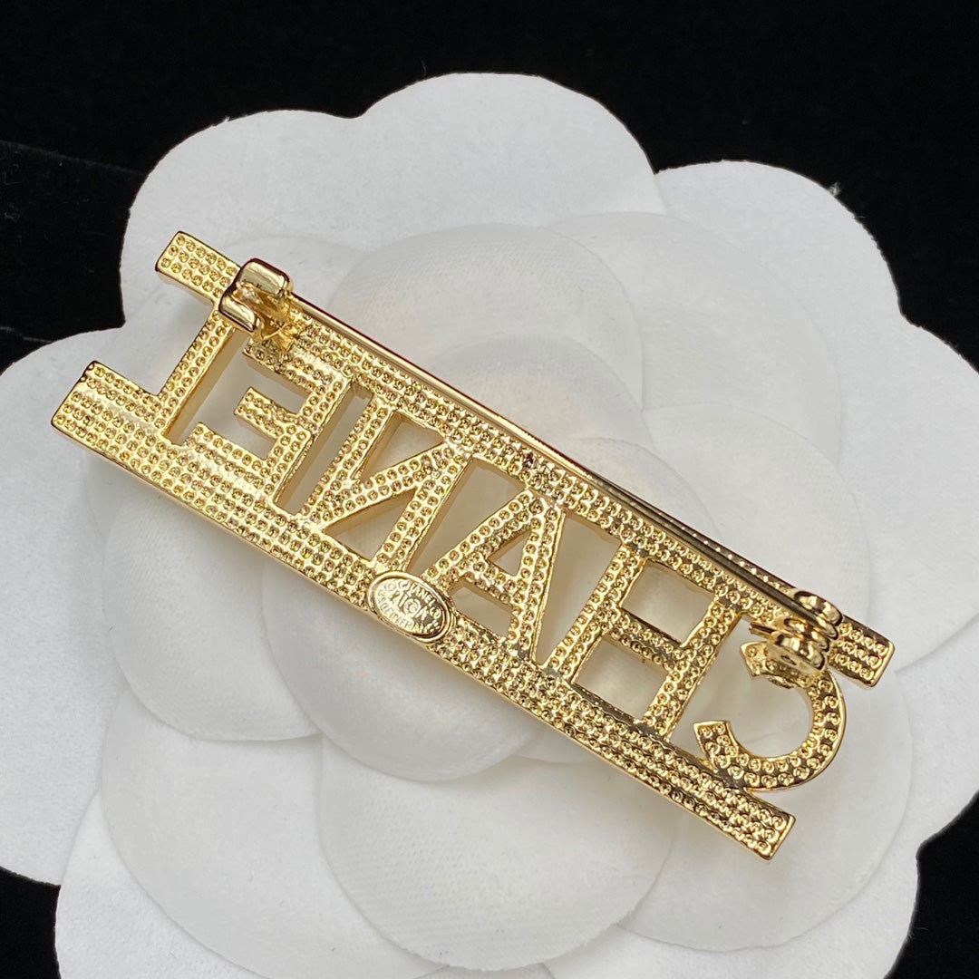 Broche de letras de diamantes brillantes