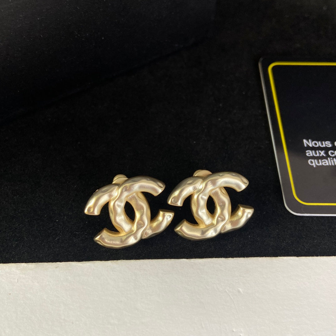 Pendientes de tuerca con letras y diseño arrugado
