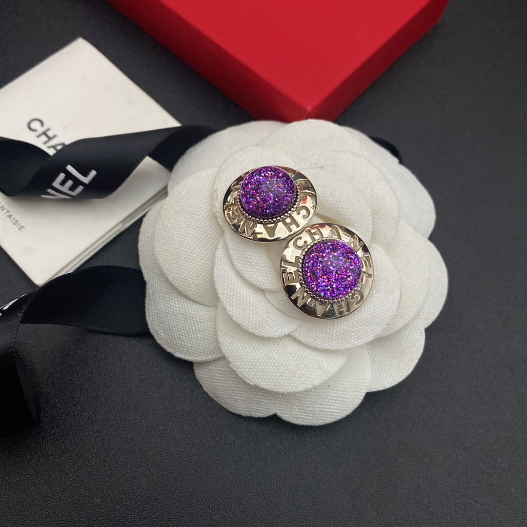 Pendientes de bola morada con letras huecas