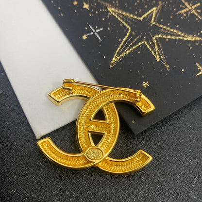 Broche dorado con letras electrochapadas