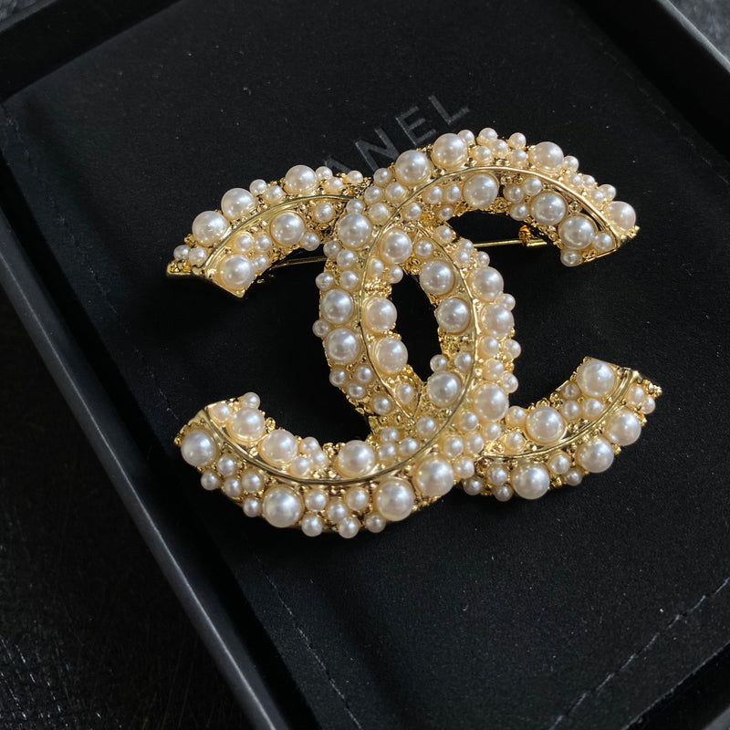Broche elegante con logo de perla