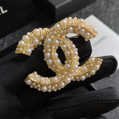 Broche elegante con logo de perla