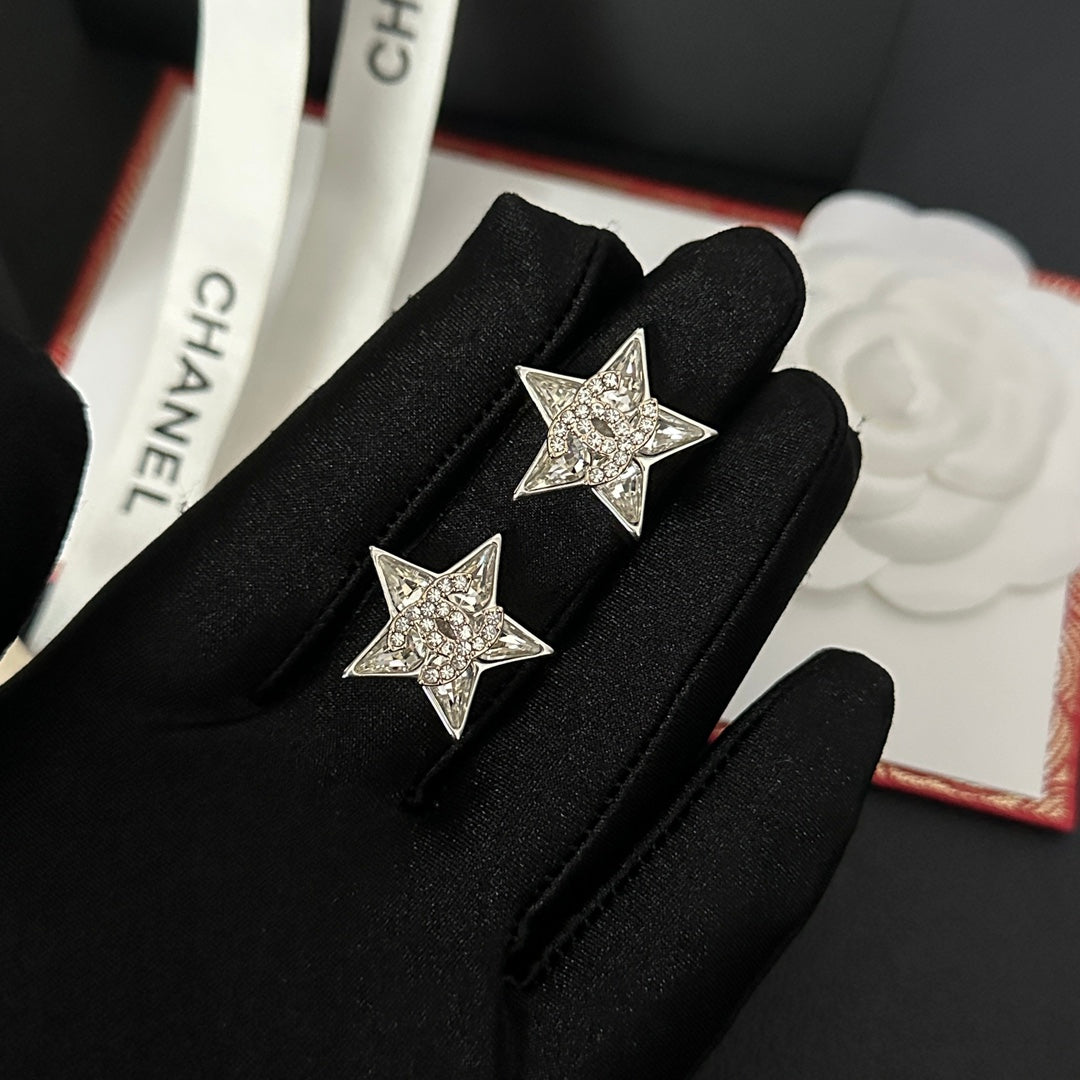 Pendientes plateados con pedrería en forma de estrella