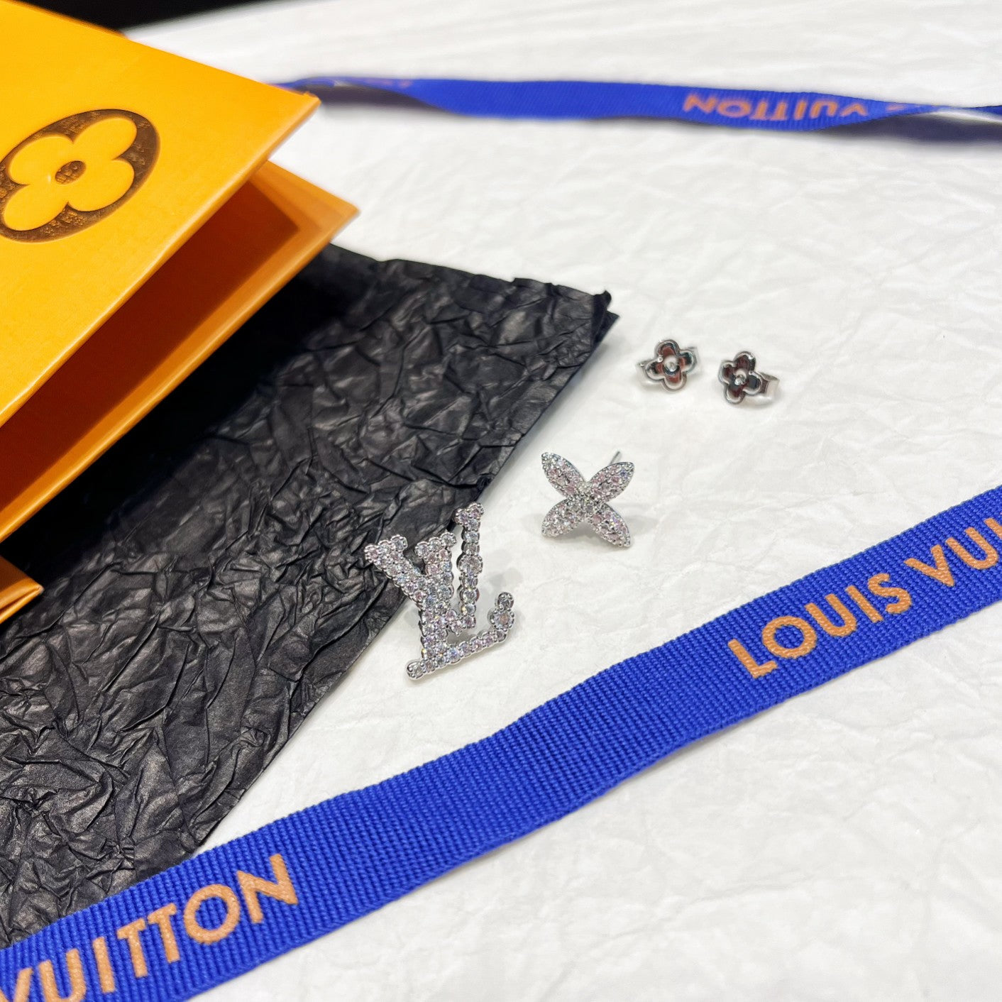 Aretes Asimétricos con Logotipo Floral y Estrás