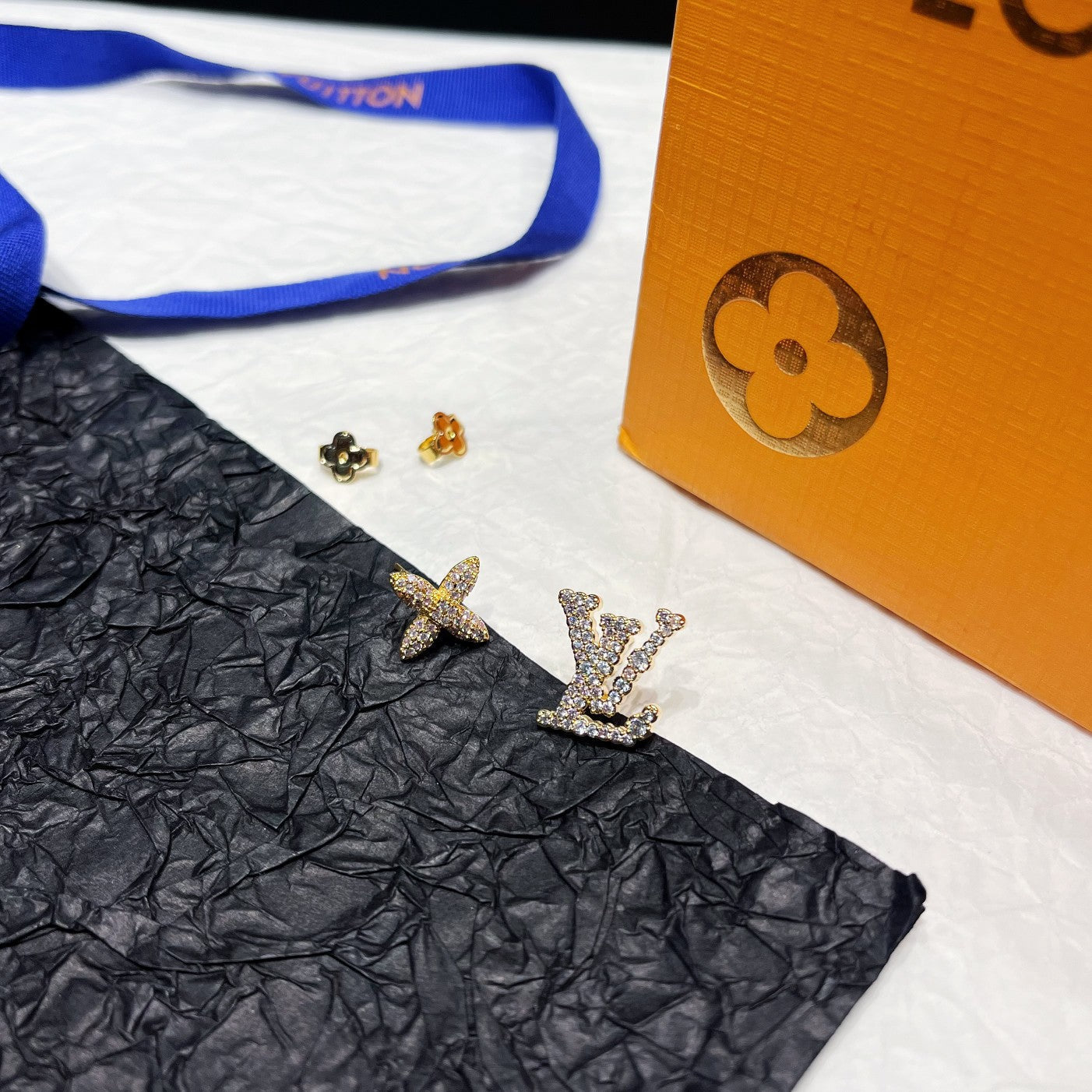 Aretes Asimétricos con Logotipo Floral y Estrás