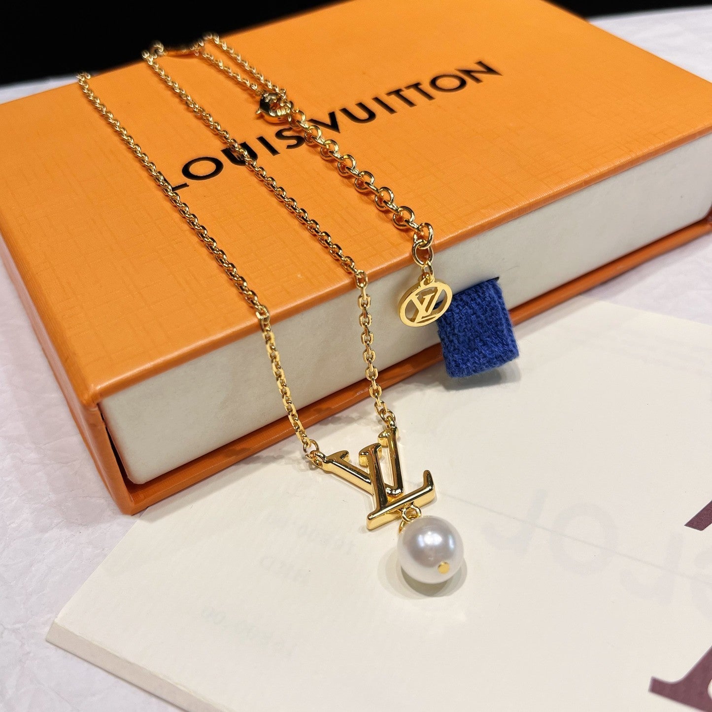 Parure de bijoux en perles avec logo iconique