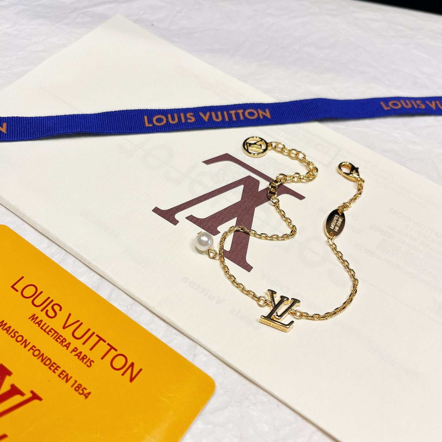 Parure de bijoux en perles avec logo iconique