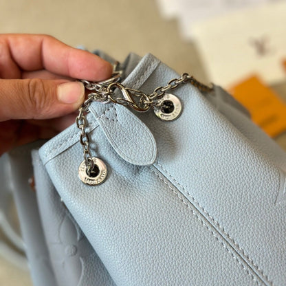 Bolso bombonera de piel azul repujada con cordón