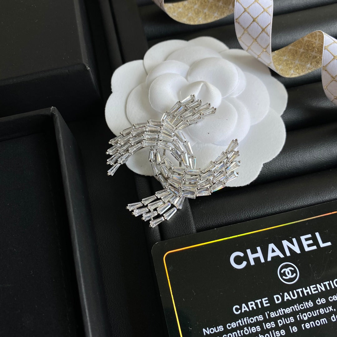 Broche con el logotipo de cristal brillante